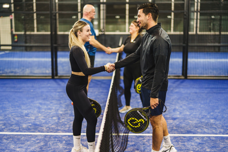 Vier padelspelers die elkaar de hand schudden op het veld bij Padelclub Nederland locatie Druten