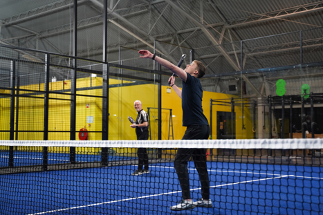 Twee padelspelers die in Druten een hoge bal spelen op het padelveld