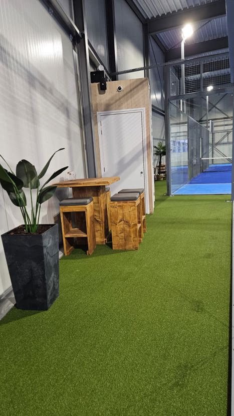 Sfeerfoto van de padellocatie in Sneek met zitplaatsen en bankjes langs de baan