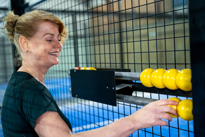 Een geconcentreerde padelspeler kijkt naar het scorebord om de puntentelling padel te controleren. Het bijhouden van de score is een fundamenteel onderdeel van de padelregels. Deze afbeelding symboliseert de spanning en focus op de padel puntentelling tijdens het spel.
